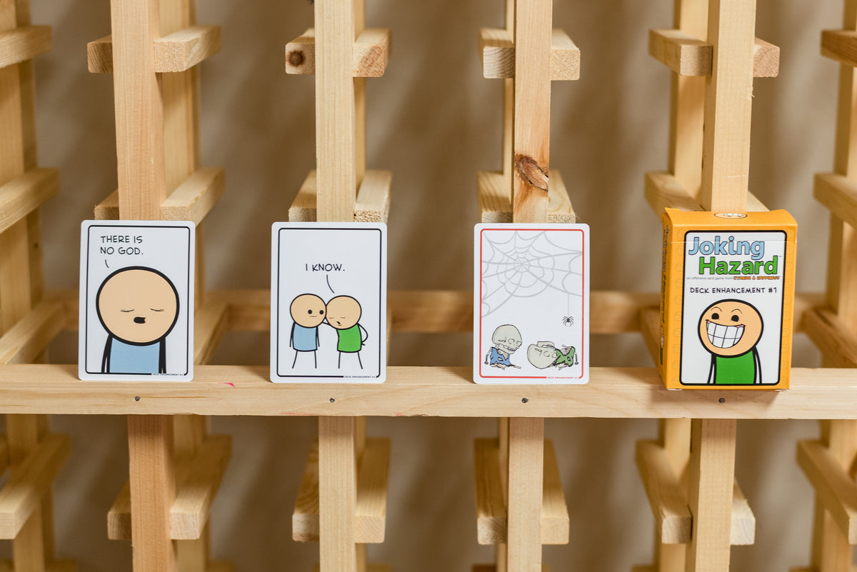 Joking Hazard Deck Enhancement #1 cards displayed on a wooden shelf