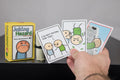 Hand holding Joking Hazard Deck Enhancement #2 cards next to the box
